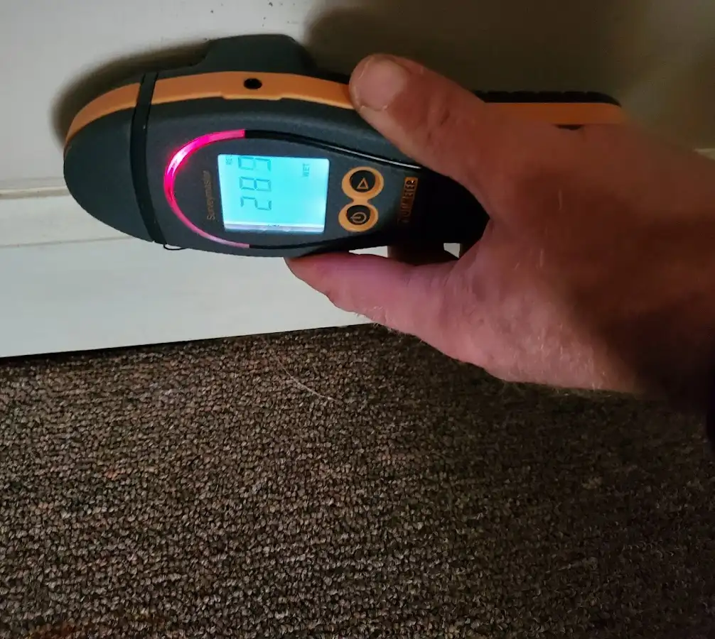 Moisture detection at baseboard during Storm Damage Restoration in Lawrence